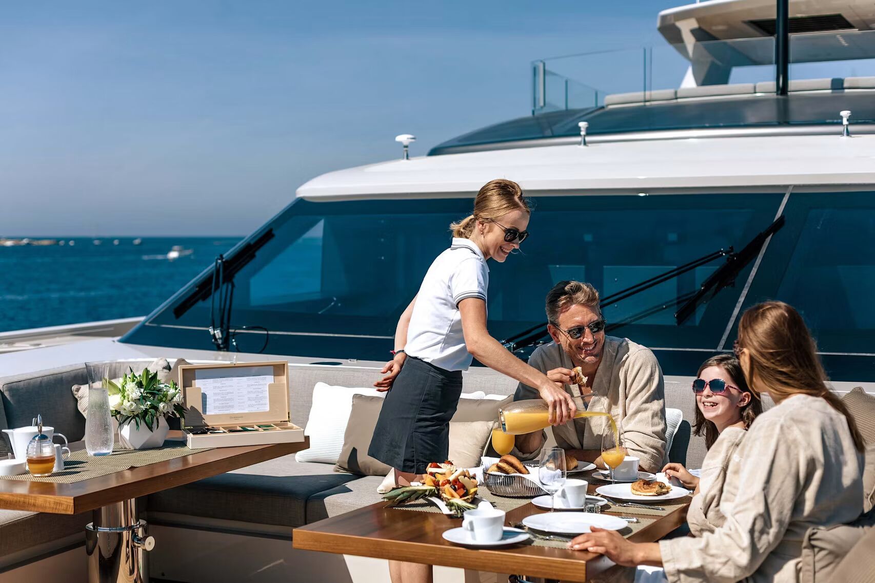 Family enjoying breakfast served on the deck of a private yacht on the Mediterranean